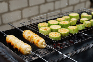 Chopped zucchini and khachapuri roasting on fire seasoned with aroma herbs and spices. Delicious fresh vegetables vegetarian grilling on barbecue smoker grid. Diet vegan bbq. Outdoor recreation in