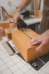 an employee is packing products into boxes to prepare for shipping to customers, a small online...
