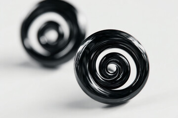 A photorealistic black earrings with surrealism-inspired spirals floating around