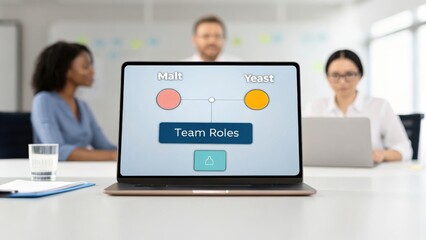 Laptop displaying team roles diagram with two women and a man in a meeting setting.