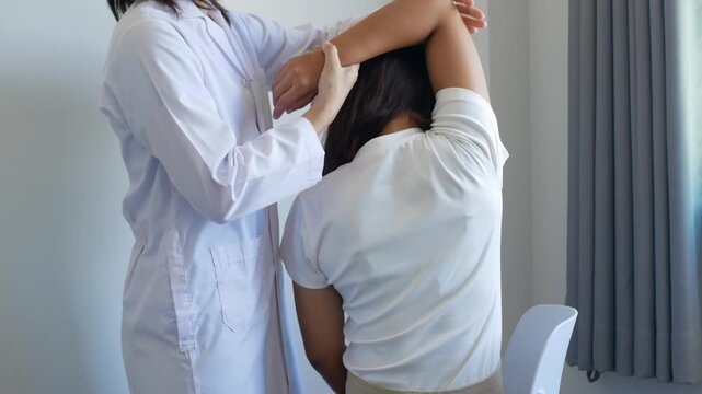 Asian female patient undergoing physical therapy with a physical therapist after suffering from prolonged and intolerable pain. She underwent pain management in a hospital.