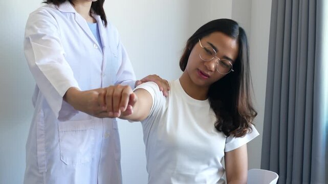 Asian female patient undergoing physical therapy with a physical therapist after suffering from prolonged and intolerable pain. She underwent pain management in a hospital.