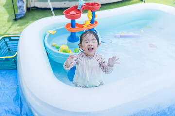 庭のプールで遊ぶ日本人の幼児