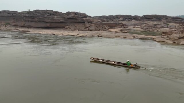 Fishermen are driving their boats on the Mekong River on the Thai border.