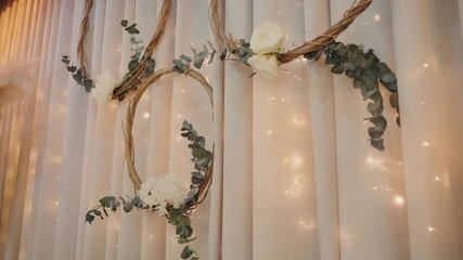 wedding floral wreaths with eucalyptus and roses hang on curtain with warm fairy lights - Powered by Adobe