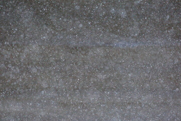 여름에 어두운 아스팔트 위에 비가 내리는 장면 