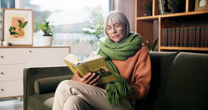 Senior woman, relax and reading book on sofa for birdwatching hobby, learning and info at retirement home. Person, literature and study for avian animal, knowledge or thinking on couch at apartment - Powered by Adobe