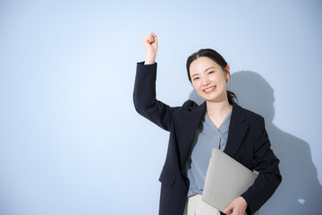 Image of a young cute woman standing in a suit with a computer, guts, etc., with an energetic young...