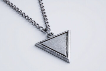 A photorealistic silver necklace with minimalism-inspired triangular pendant