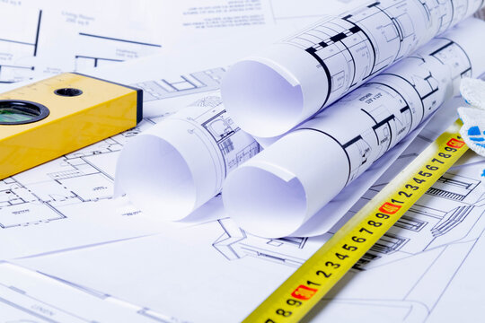 Builder's tools on the scheme of the house. Preparing to build a house. Builder's gloves and blueprints..
