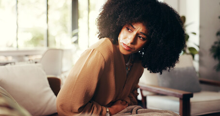 Girl, stomach and cramps or pain on sofa for menstruation, ovarian cysts and discomfort in lounge....