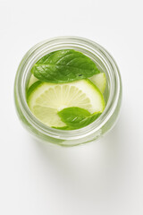 Obraz premium Lime and mint infused water in a glass jar isolated on white background