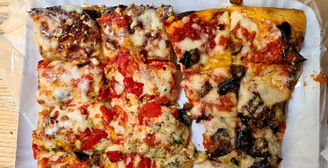Evocative close-up image of pizza al trancio with tomato, mozzarella and fried aubergines
