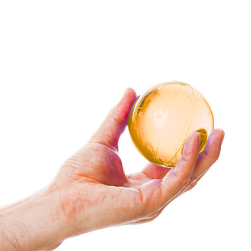 Golden orb held in hand isolated against white background for crystal ball concept and spiritual symbolism.