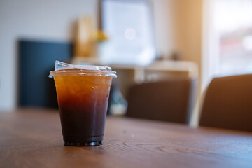 Close-up of Americano ice coffee or black coffee in cup mug on  wood desk office desk in coffee shop at the cafe in garden,during business work concept