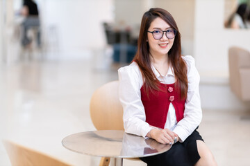 Portrait of beautiful happy Smiling asian woman relaxing sitting in cafe interior in coffee shop...