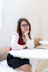 Portrait of beautiful happy Smiling asian woman relaxing sitting in cafe interior in coffee shop...