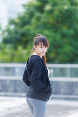 Portrait of beautiful asian Young woman in Black robe sportswear working out outside. training on...