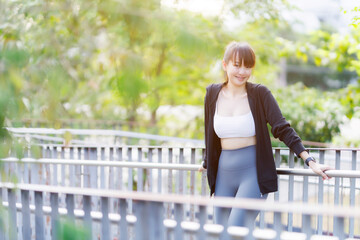 Portrait of beautiful asian Young woman in Black robe sportswear working out outside. training on...