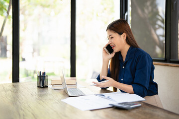 Happy joyful confident asian business lady, broker or officer, sitting at table in a modern home...