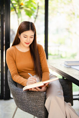 Freelancer Woman writing on notebook  Sitting At Home office . Happy Smiling Working Online While...