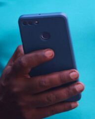 A person is holding a blue cell phone in their hand