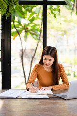 Pensive young female working by desk holding pen and notepad making notes create new idea....