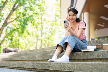 casual student Woman sittung at steps texting on a mobile phone or Listening Music Media...