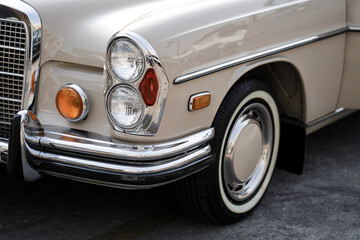 The chrome bumper of a vintage car glows with light, adding to the car classic allure and sleek...