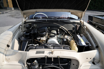 The engine and battery compartment of a classic car, with its detailed mechanical and electrical...
