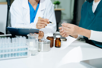 scientists in lab coats conducting research, handling glassware, and working with chemicals