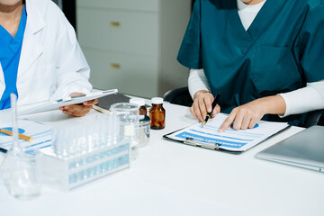 scientists in lab coats conducting research, handling glassware, and working with chemicals