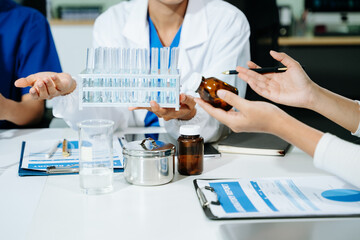 scientists in lab coats conducting research, handling glassware, and working with chemicals