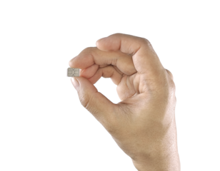A person's hand pinches a small silver nano-SIM card between the thumb and index finger, isolated on a white background.