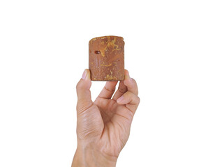 Palm sugar held by hand, representing organic sweetener from coconut or sugar palm tree
