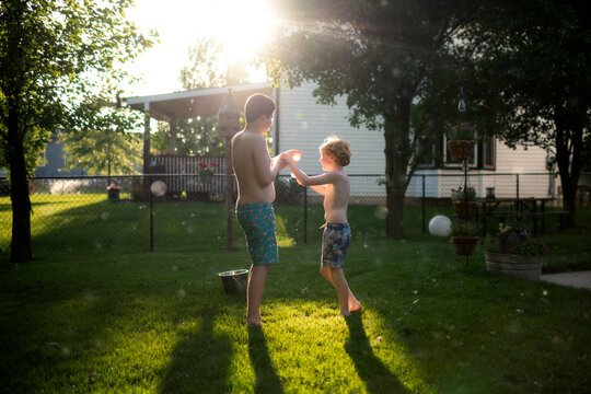 Water fight joy between kids in evening light outdoors