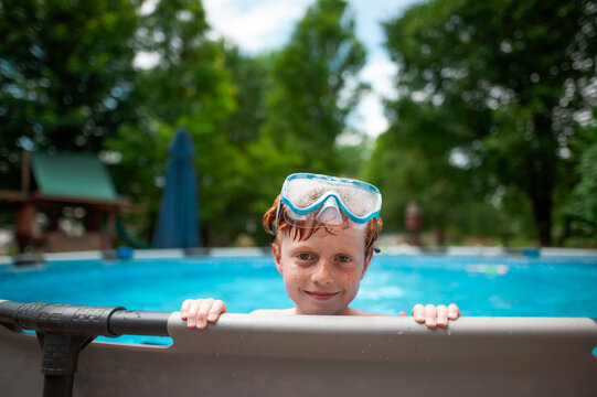 Kid with goggles smiles during fun summer pool afternoon