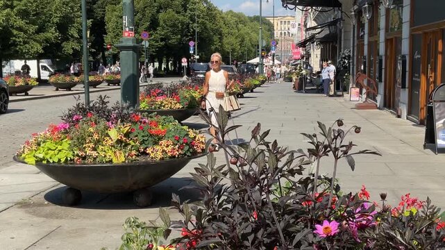 Woman walking the city center streets in Oslo, Norway.  Footage from Karl Johan street with the royal castle in the background.