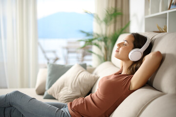 Woman relaxing listening audio on headphone at home
