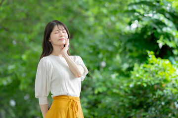 新緑の中で立つ女性