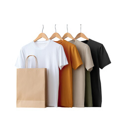 Five simple t-shirts in varying colors on hangers, with a brown paper bag