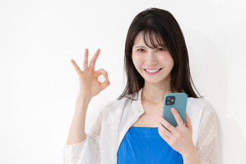 笑顔でスマホを持つ女性