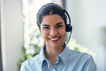 Smiling customer service representative using a headset in an office