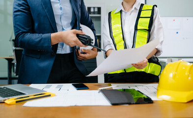 Creative architect projecting on the big drawings with architectural project at construction site...