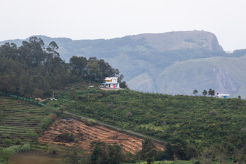 Hillside home overlooking cultivated slopes and distant mountains in kodaikanal, tamil nadu