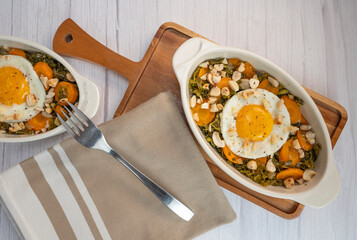 Recipe for kale, carrot and garlic poellee, chopped hazelnuts, cashews and almonds, and fried egg with toasted garlic bread and olive oil