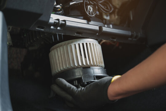 Car Air Blower Motor Repair by Mechanic Hand Under Dashboard