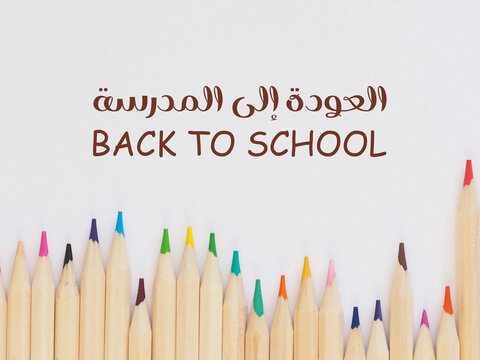 Colorful pencils arranged on a white background with “Back to School” in English and Arabic — a vibrant welcome to a new school year - Powered by Adobe