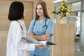 Asia doctor woman working and talking with Caucasian woman medical student at hospital	