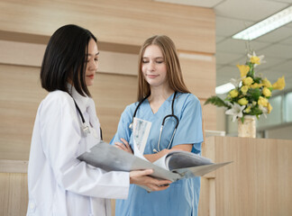 Asia doctor woman working and talking with Caucasian woman medical student at hospital	